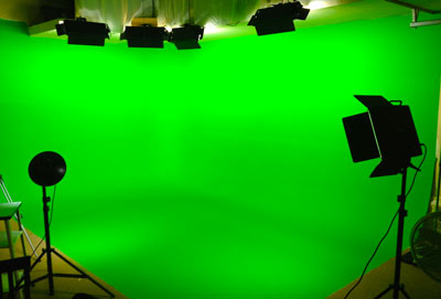 Green screen studio cyclorama shown here with lighting packages and film crew off the stage.